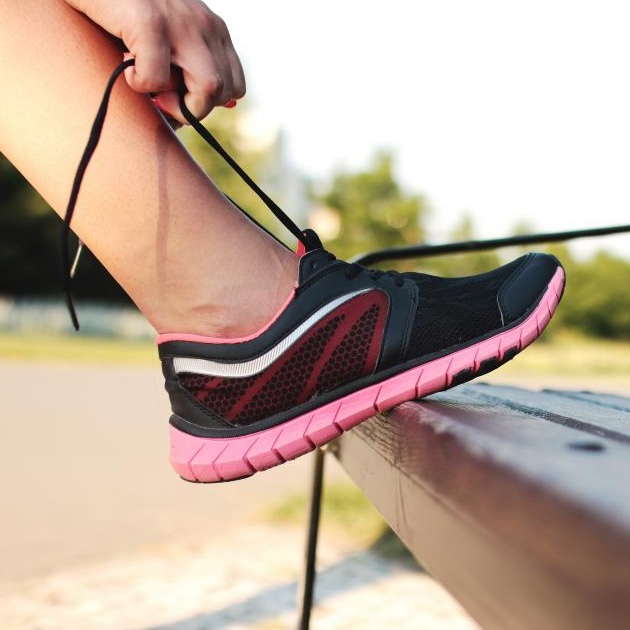 Running shoe being laced up outdoors